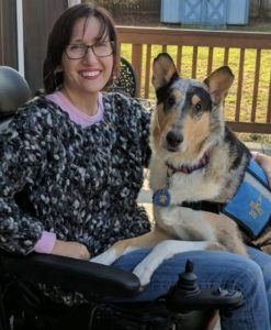 Service dog with professional dog trainer seated in wheelchair