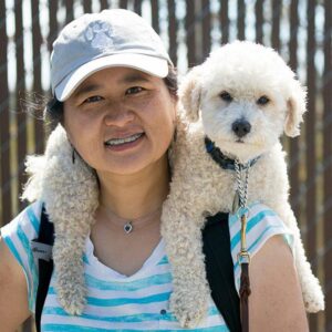Service Dog Coach Yuching Desch with her small dog on her shoulders.