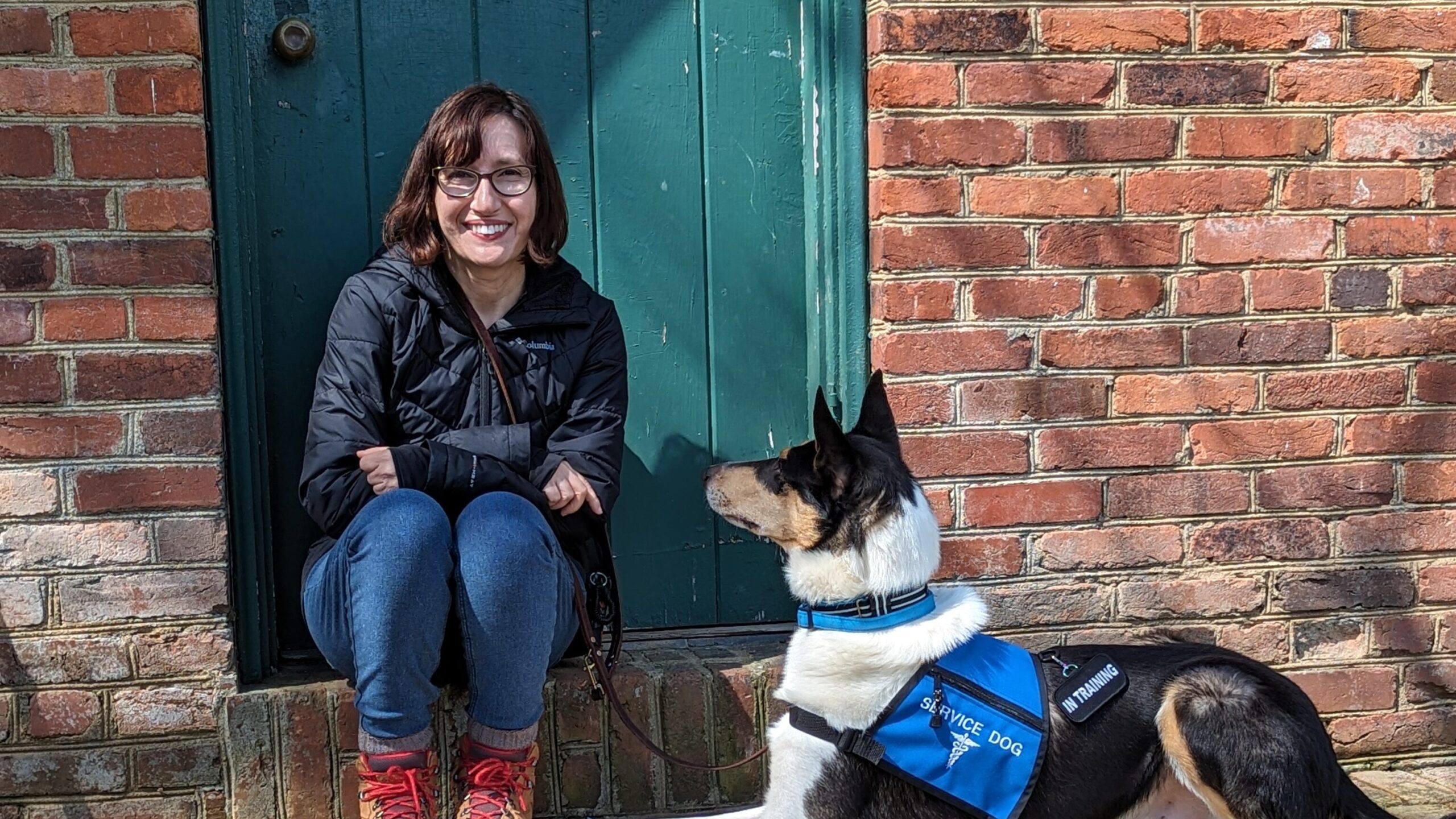 Woman seated with collie service dog next to her