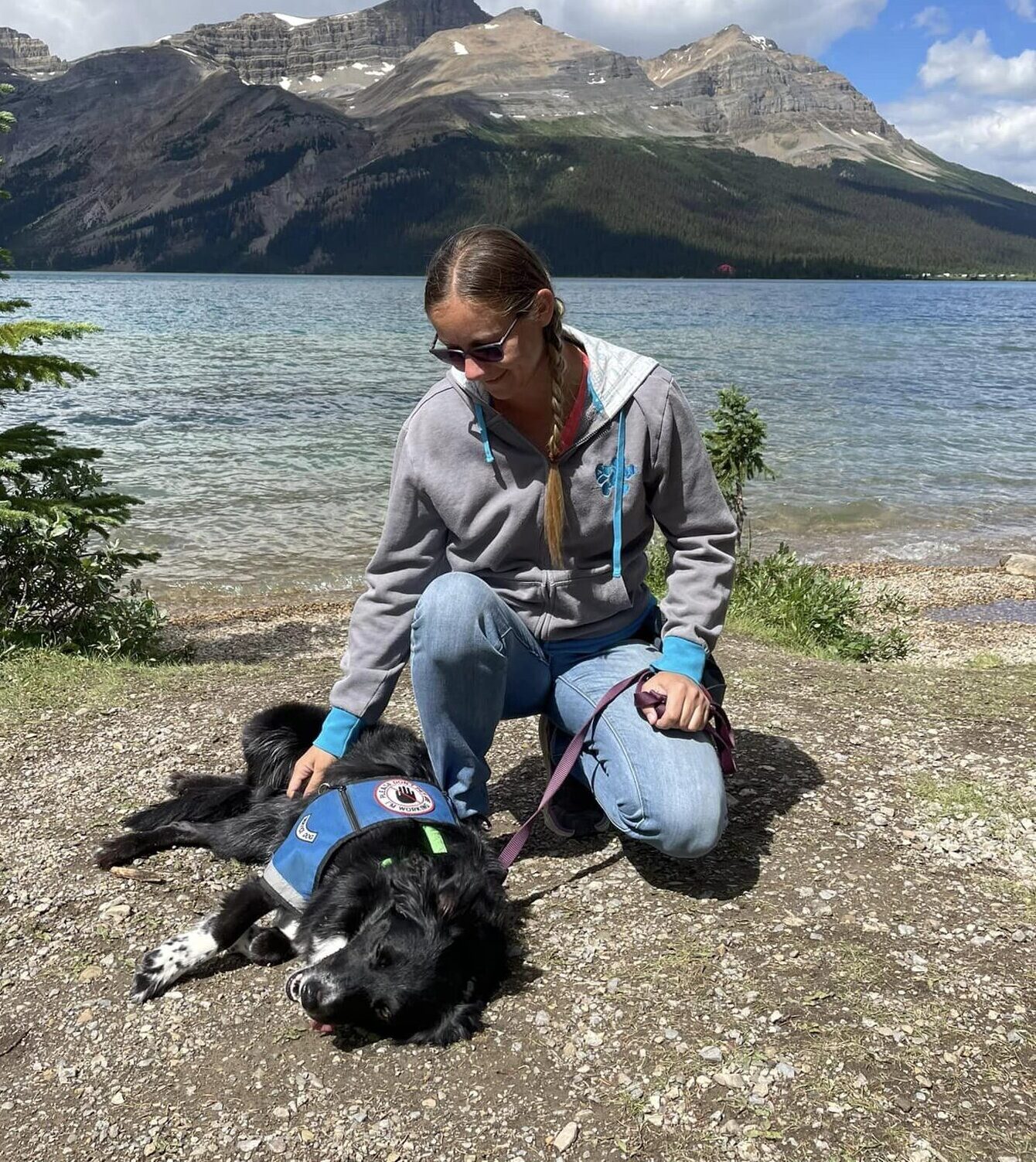 Woman smiling at service dog lying down