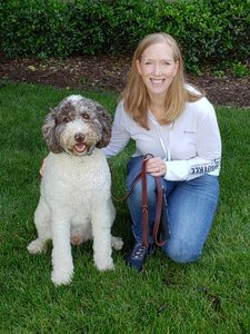 Jeanne Hodson smiling with labradoodle next to her